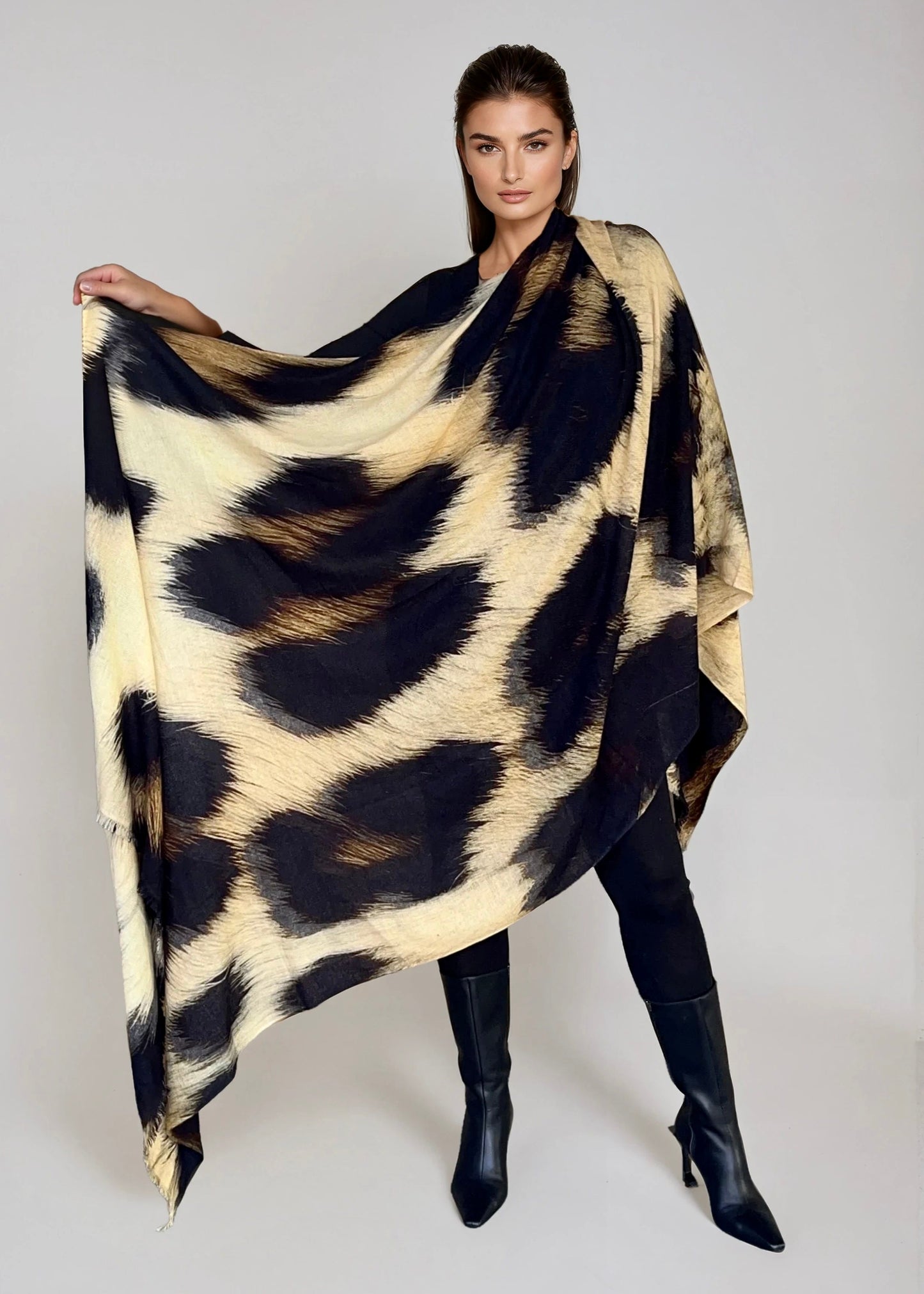 "Woman wearing a extra large cashmere wool wrap with snow leopard print pattern showing luxury animal print design"