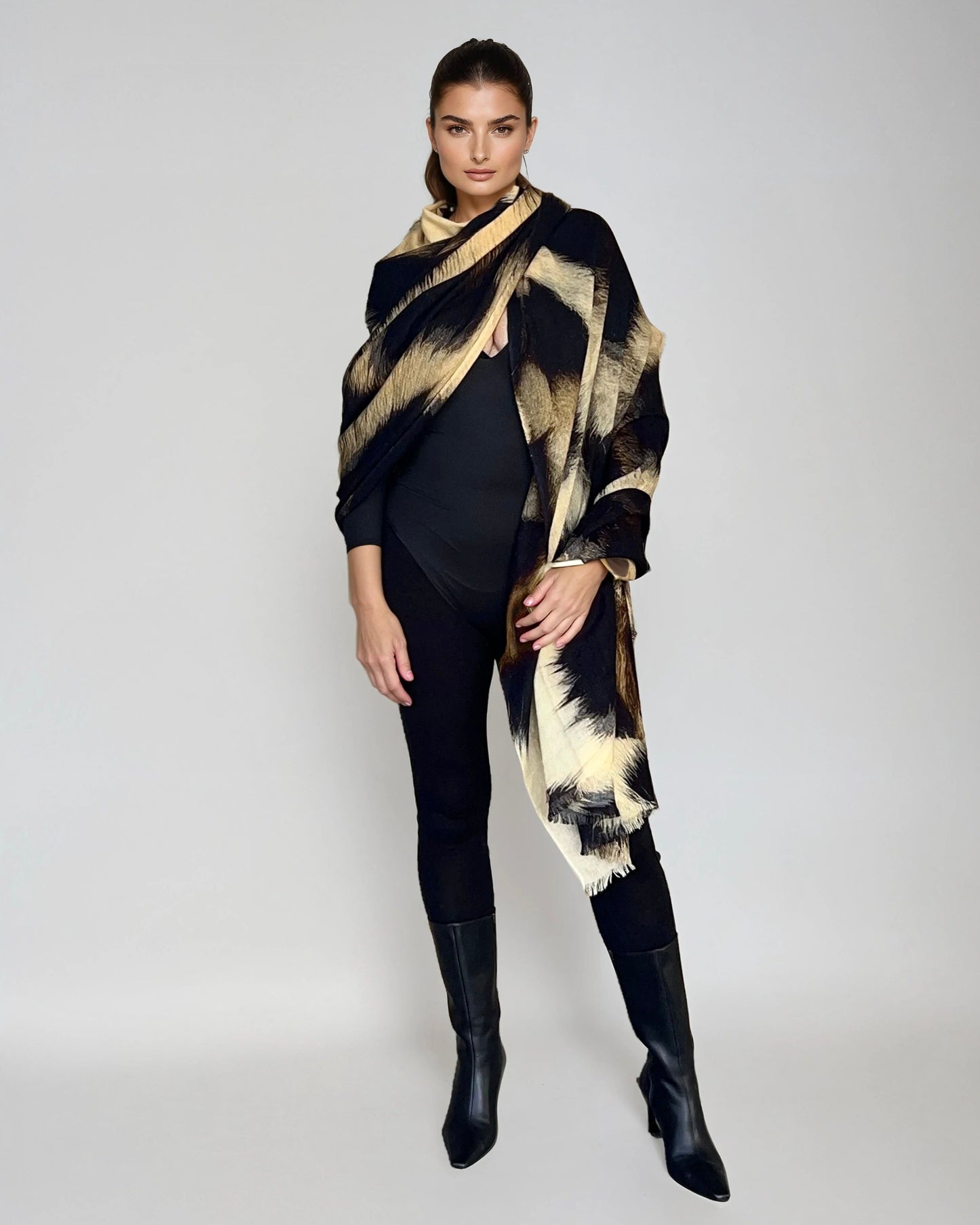 "Woman wearing extra large cashmere wool wrap with snow leopard print pattern showing luxury animal print design"