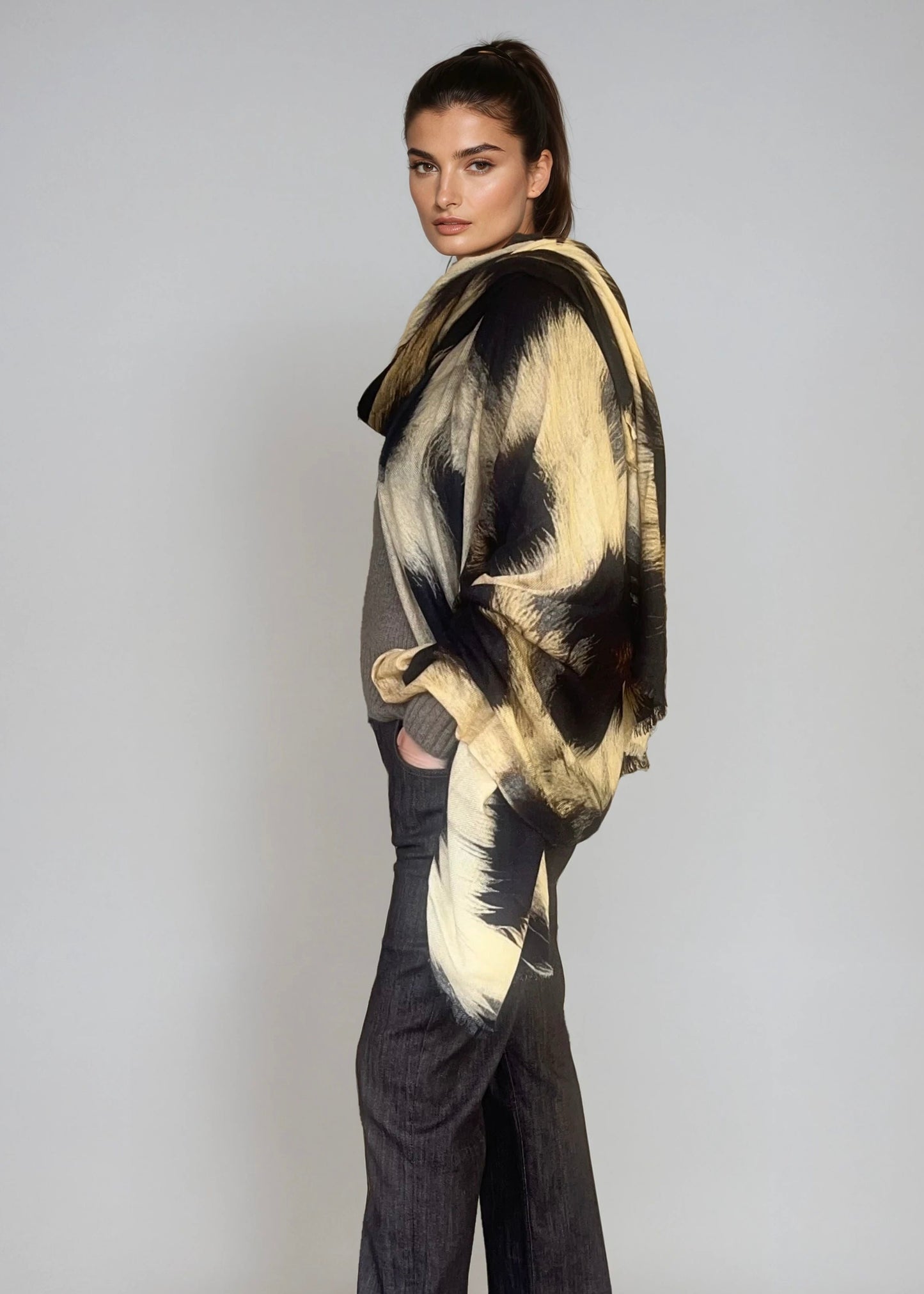 "Woman wearing extra large cashmere wool wrap with snake print pattern showing luxury animal print design"
