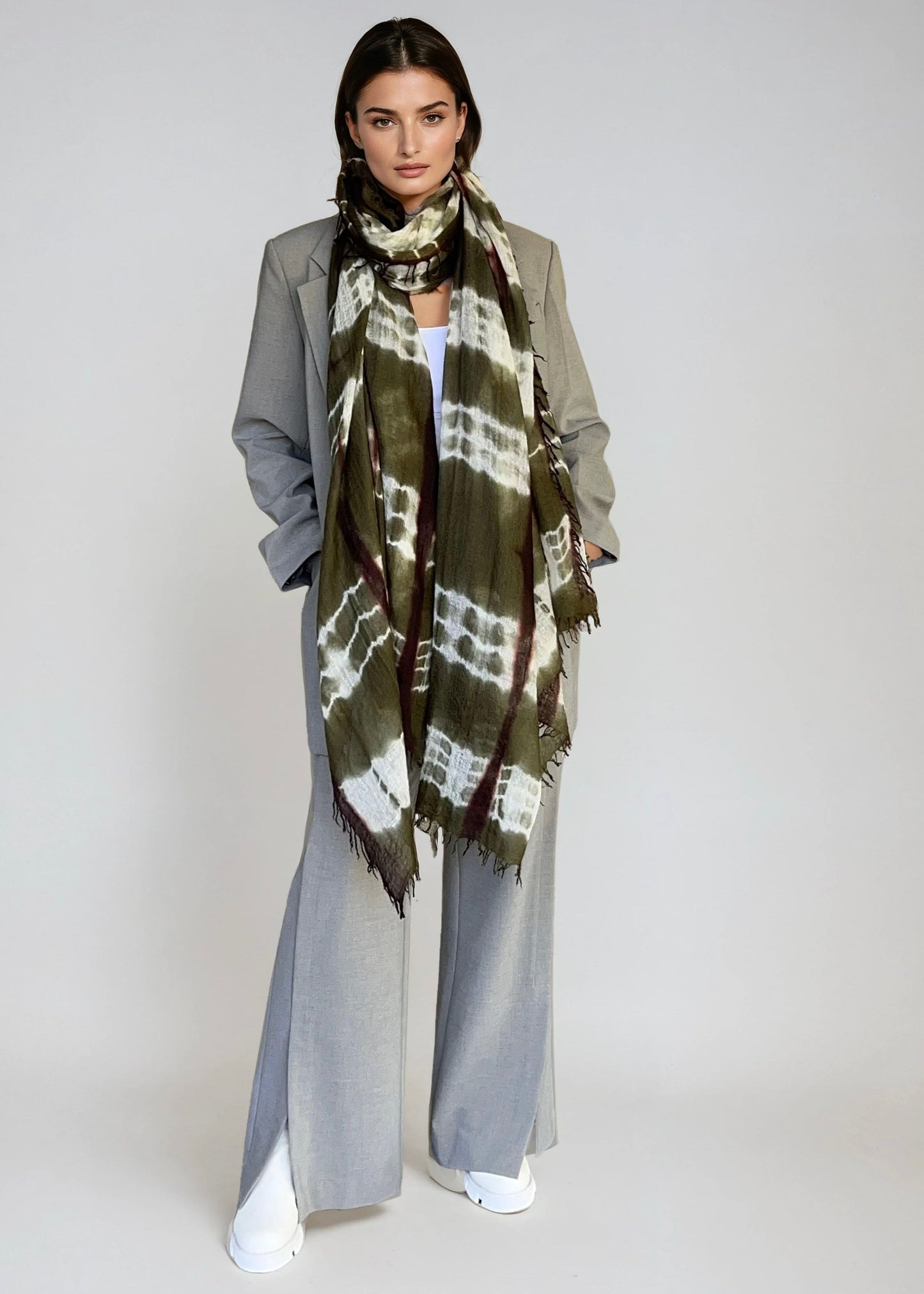 Woman wearing a green and brown patterned scarf on a white background