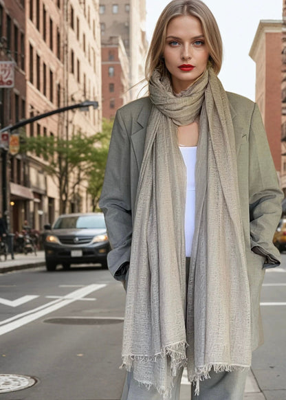 Woman standing on a city street wearing a suit and  soft grey extra large cashmere scarf