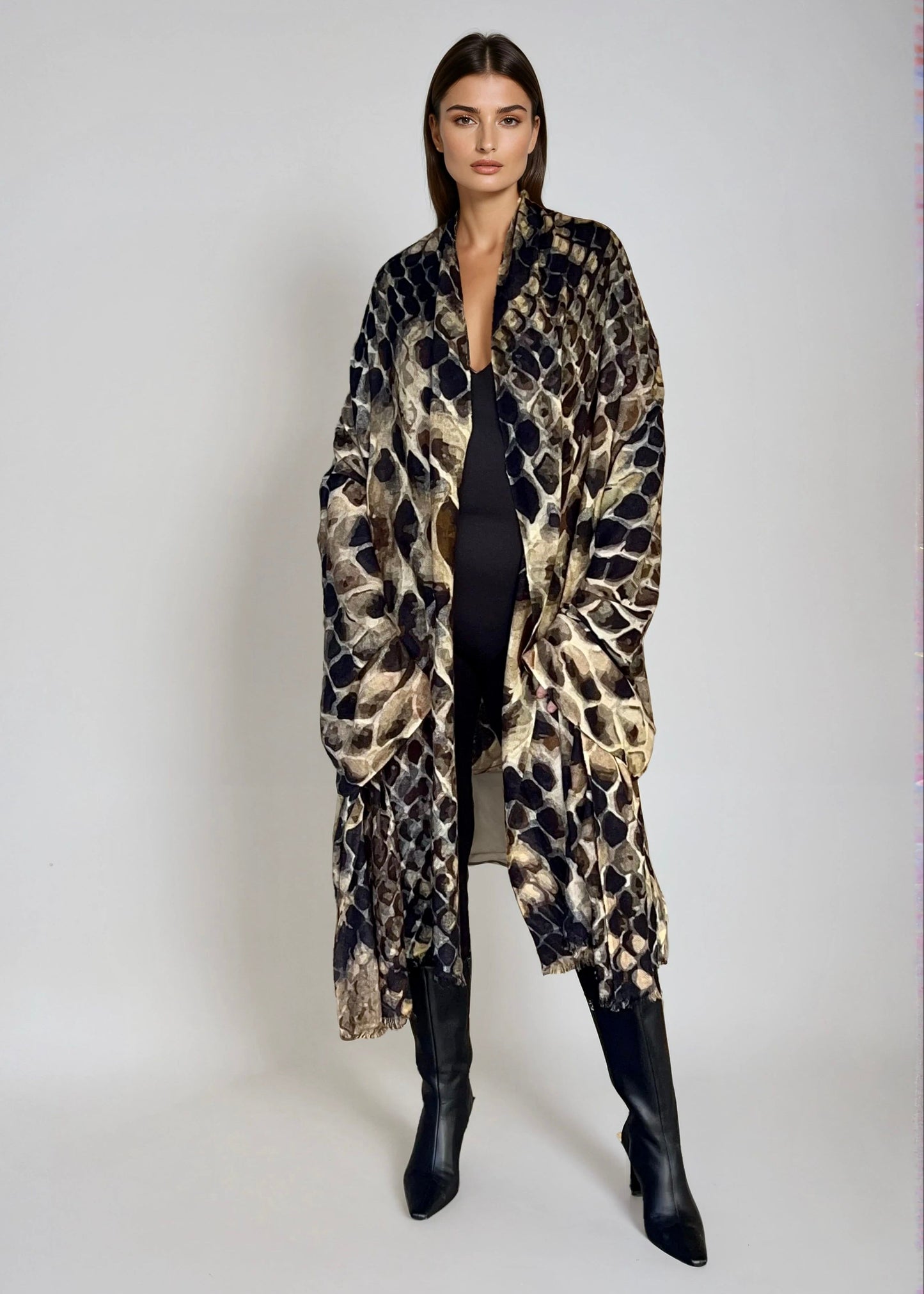 "Woman wearing cashmere wool, extra large wrap with snake print pattern showing luxury animal print design"