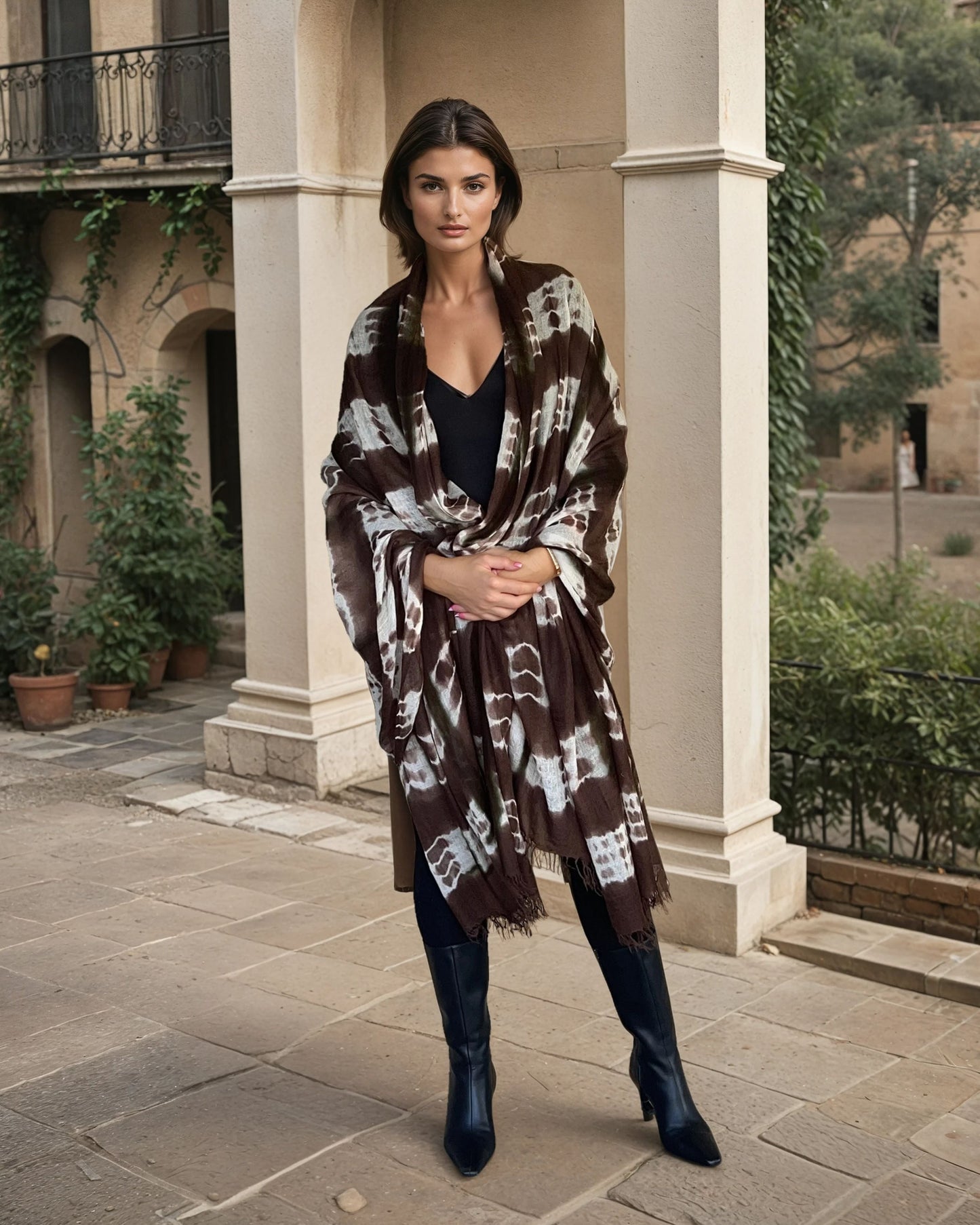 "Woman wearing limited edition hand tie-dyed, extra large cashmere wrap in earth brown ,white and a touch of forest green showing unique color patterns"
