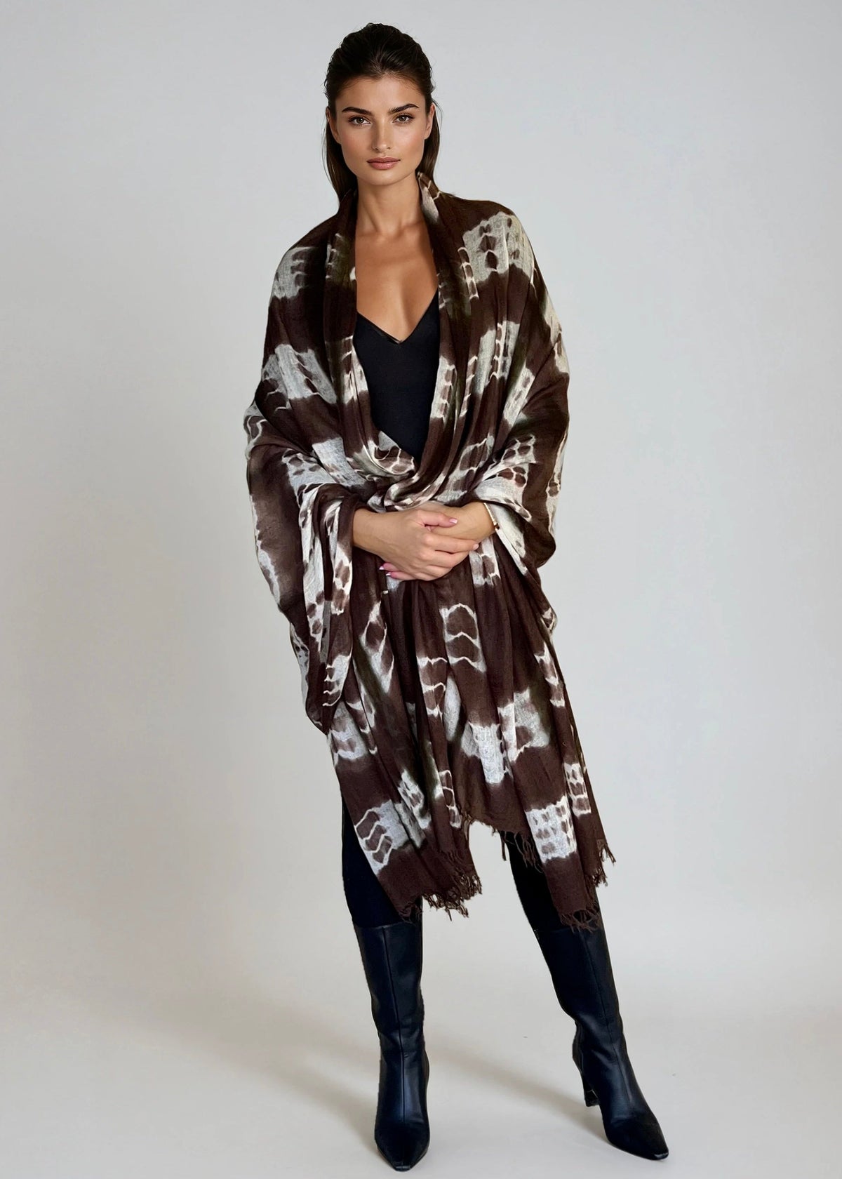 "Woman wearing limited edition hand tie-dyed cashmere wrap in earth brown ,white and a touch of forest green showing unique color patterns"