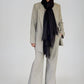 Person wearing a gray suit with a black scarf on a white background