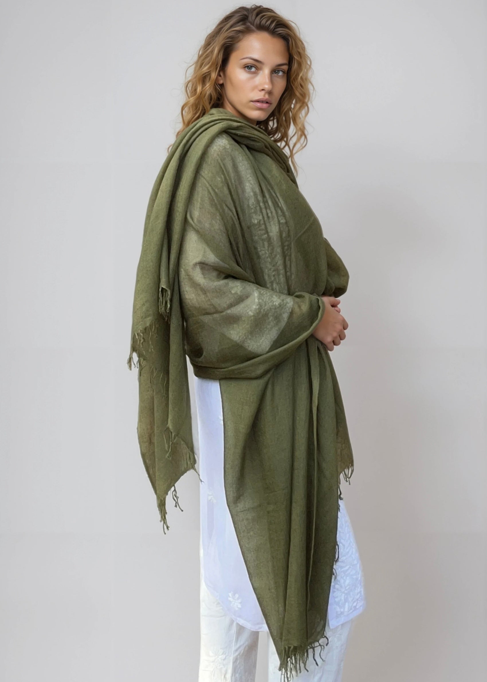 Olive green handwoven cashmere wrap draped over shoulders