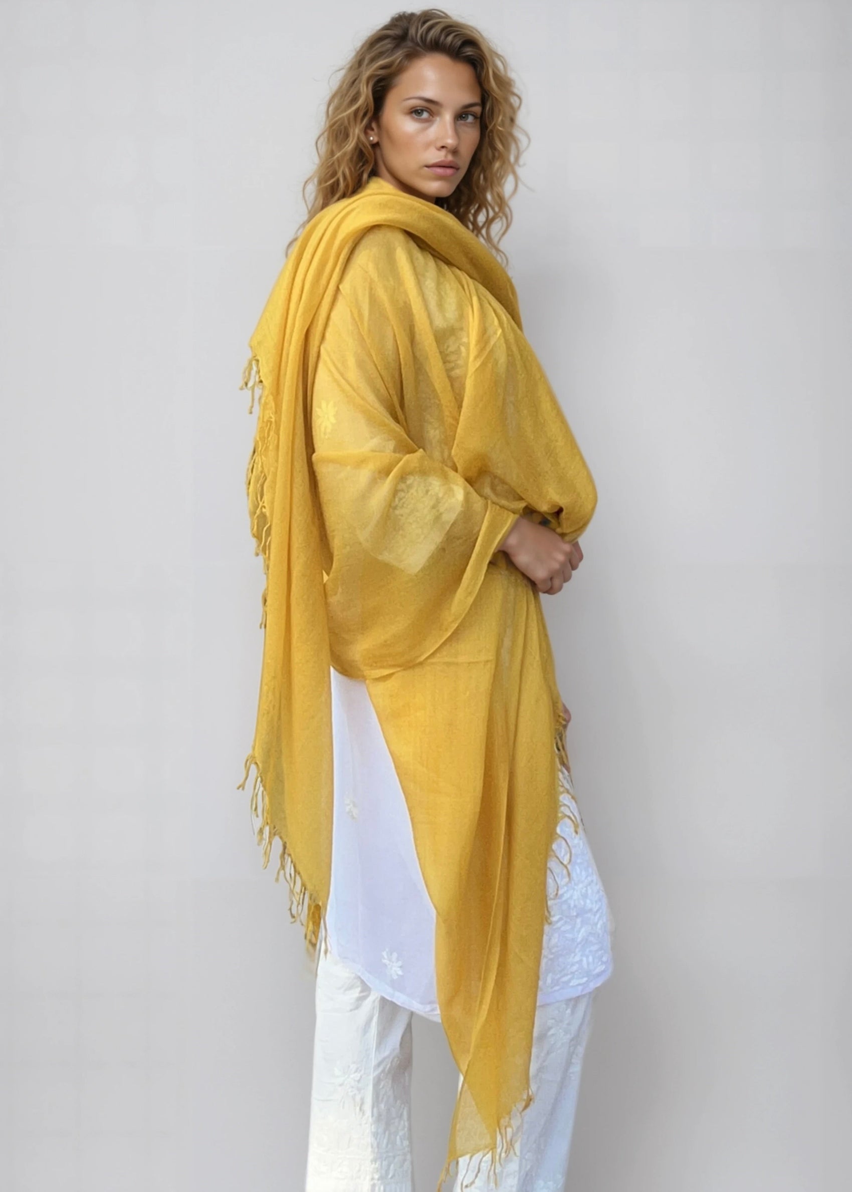 Saffron cashmere wrap draped as oversized luxury shawl