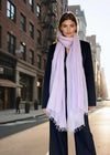 Woman wearing a extra large cashmere lavender scarf on a city street