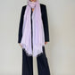 Woman wearing a extra large cashmere lavender scarf in a studio.