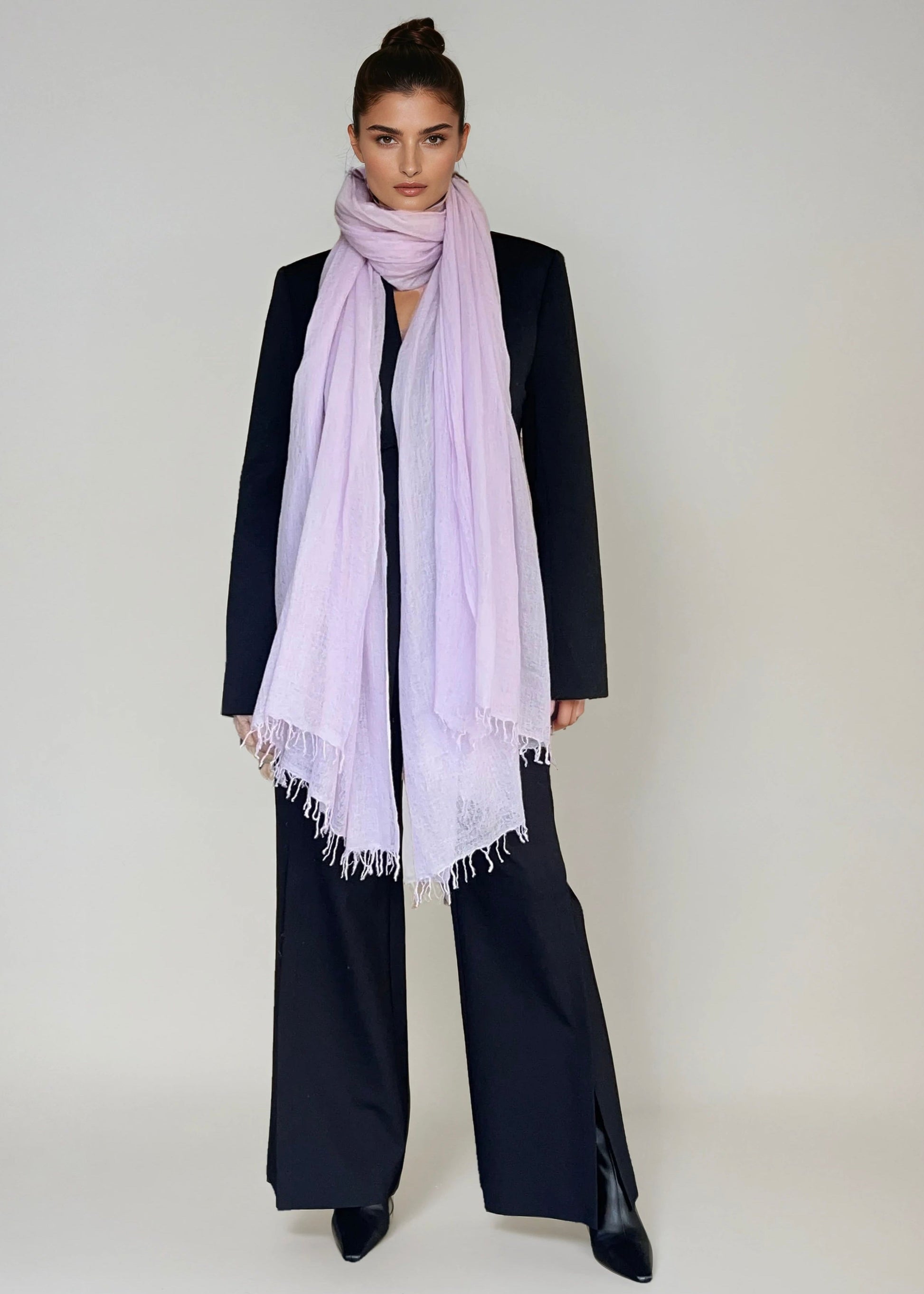 Woman wearing a extra large cashmere lavender scarf in a studio.