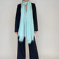 Woman wearing a extra large, cashmere opal blue shawl on a plain background.