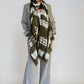Woman wearing a green and brown patterned scarf on a white background