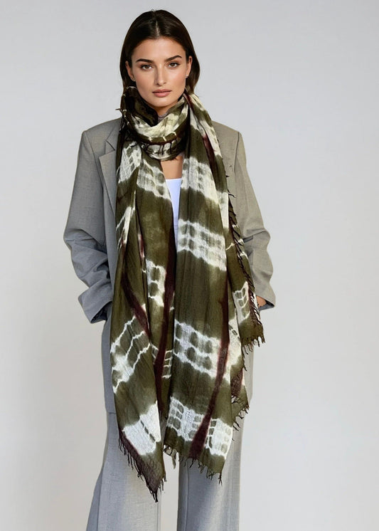 Woman wearing a green and brown patterned scarf on a white background