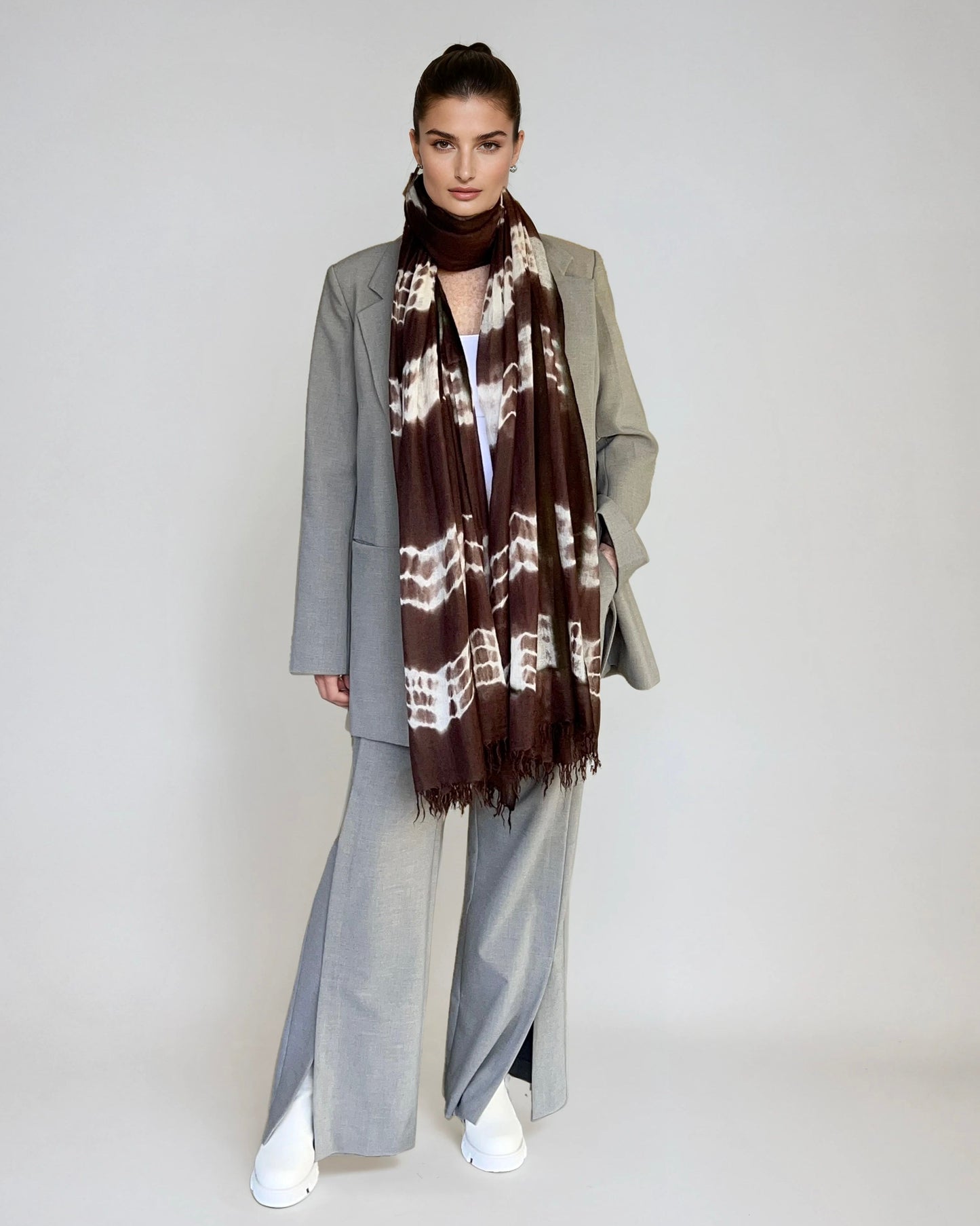 Woman wearing a patterned scarf with a plain background