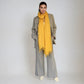 Woman wearing a yellow scarf and gray outfit on a white background