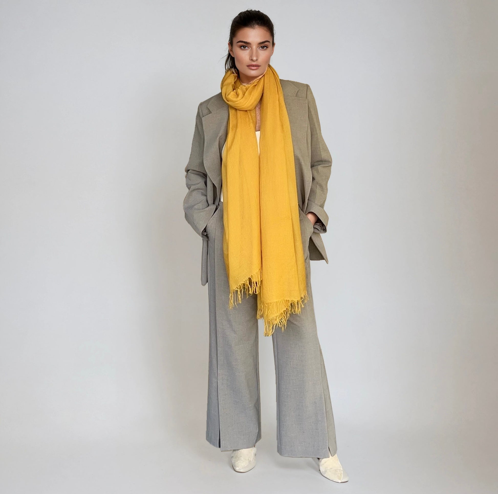 Woman wearing a yellow scarf and gray outfit on a white background