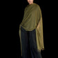 Woman wearing a green shawl over a dark outfit on a black background
