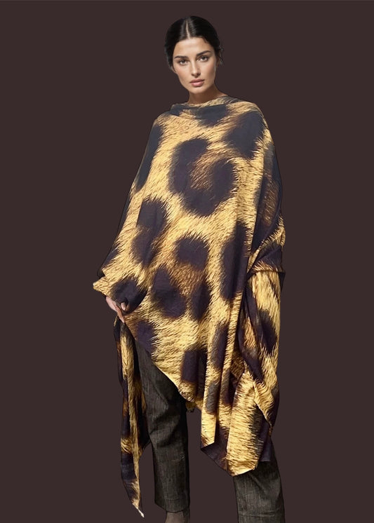 Woman wearing a leopard print extra large wraps against a dark background