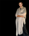 Woman wearing a beige scarf against a black background