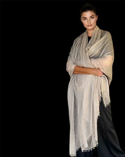 Woman wearing a beige scarf against a black background