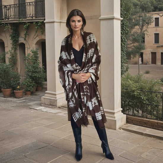 "Woman wearing limited edition hand tie-dyed, extra large cashmere shawl in earth brown ,white and a touch of forest green showing unique color patterns"